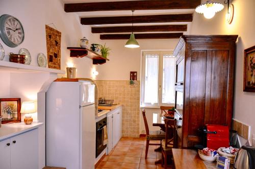 Il comprend une cuisine équipée d'un réfrigérateur blanc et d'une table. dans l'établissement Casetta sulla Vallata, à Pitigliano