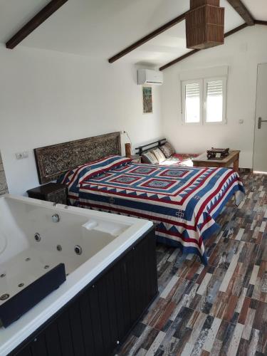 1 dormitorio con cama y bañera en Villa Bali con jacuzzi climatizado y piscina climatizada con jacuzzi, en Chiclana de la Frontera