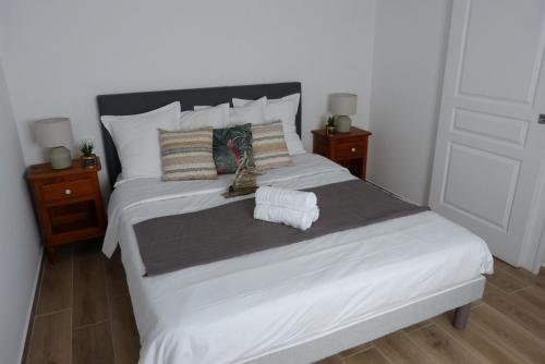 a bedroom with a large bed with two night stands at Mini villa T2 climatisée, vue mer, cosy & moderne in Olmeto