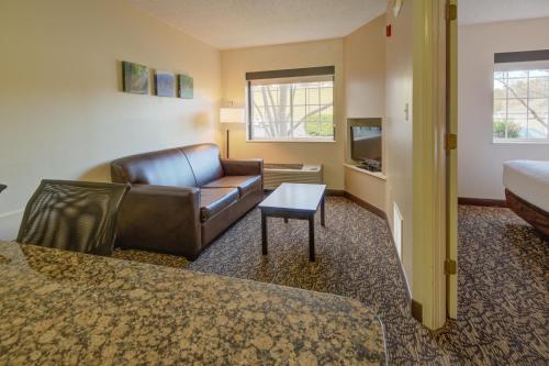 a living room with a leather couch and a table at LeConte Hotel & Convention Center, an Ascend Collection Hotel in Pigeon Forge