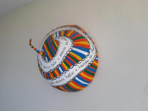 a colorful eyeball hanging on a wall at Casa d' Avó Zeza in Jardim do Mar