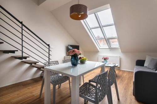 a dining room with a white table and chairs at Prague Tales Boutique Residence by Dwellfort in Prague