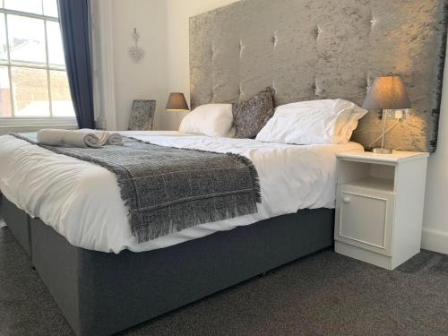 a bedroom with a large bed with white sheets and pillows at The Jubilee Hotel - with Spa and Restaurant and Entertainment in Weymouth