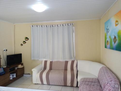 - une petite chambre avec un canapé et une fenêtre dans l'établissement Casa na Ilha da Crôa/Barra de Santo Antônio, à Barra de Santo Antônio