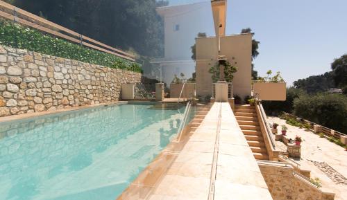 a swimming pool with stairs leading to a building at Villa Douros in Parga