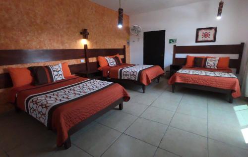 a hotel room with two beds and a bench at Kali Huasteca Posada in Ciudad Valles