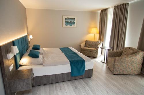 um quarto de hotel com uma cama e duas cadeiras em Hotel Willmeroth Windeck em Windeck