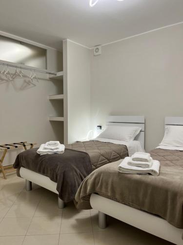 two beds in a white room with towels on them at Casa Pati in Montescaglioso