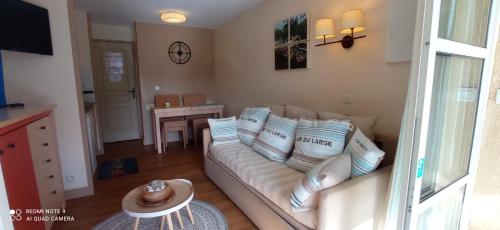 a living room with a white couch and a table at Cap Esterel Rez de jardin D2 in Saint-Raphaël