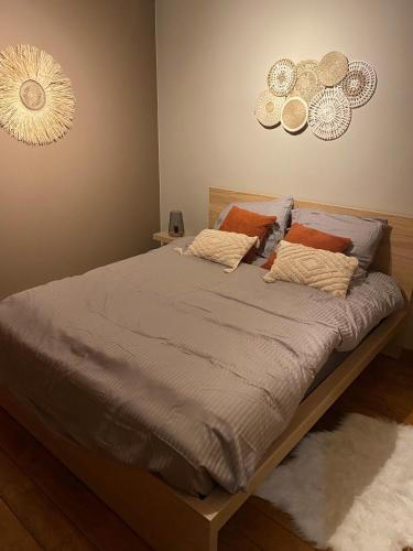 a bed in a bedroom with two clocks on the wall at Mon petit cocon in Jalhay