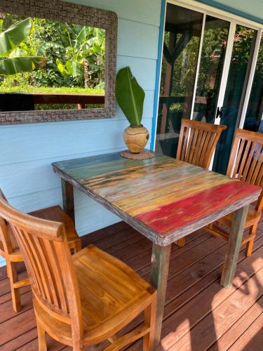 a wooden table and chairs on a porch at bungalow chez sofpat in Uturoa