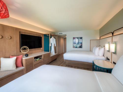 a hotel room with two beds and a tv at Crowne Plaza Resort Guam in Tumon