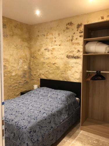 une chambre avec un lit et une étagère dans l'établissement Superbe Appart Rustique, à Arles