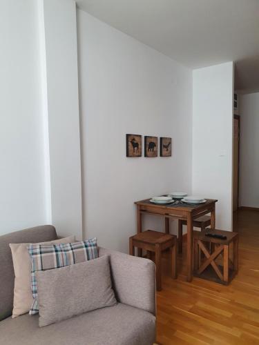 a living room with a couch and a table at PLANINSKO JUTRO - Brzeće Centar Apartments, Kopaonik in Brzeće