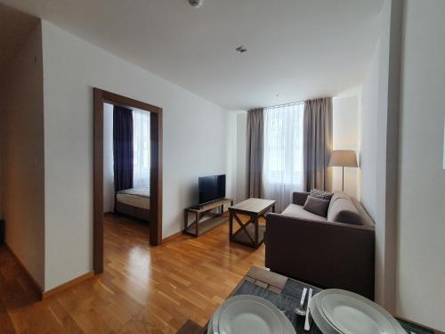 a living room with a couch and a table at PLANINSKO JUTRO - Brzeće Centar Apartments, Kopaonik in Brzeće