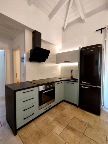 a kitchen with a black refrigerator and a sink at Villa Semipuella in Agios Nikitas