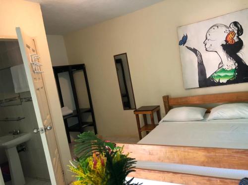 Schlafzimmer mit einem Bett mit Wandgemälde in der Unterkunft Sunshine Hotel Little Corn Island in Little Corn Island