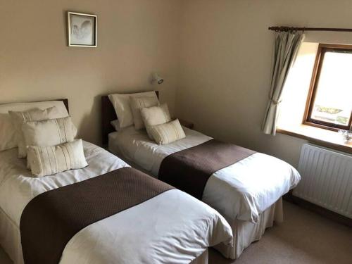 1 dormitorio con 2 camas y ventana en Sycamore Cottage en Appleby