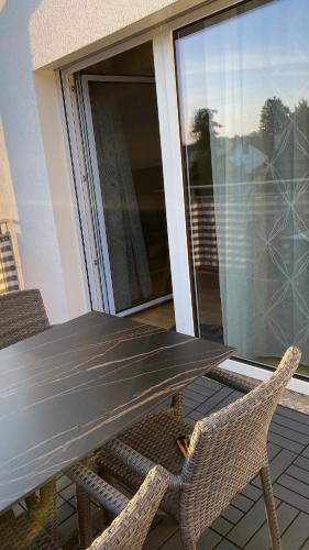 a wooden table and chairs on a balcony with a view at Wein Kultur Apartment Flavia Solva in Wagna