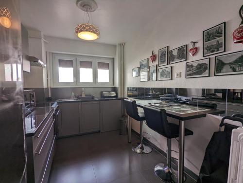 une cuisine avec un comptoir, une table et des chaises dans l'établissement CityCosy Strasbourg - Art Style, à Strasbourg