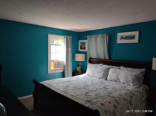 a blue bedroom with a bed and a window at Thompson House Cape Cod in South Yarmouth