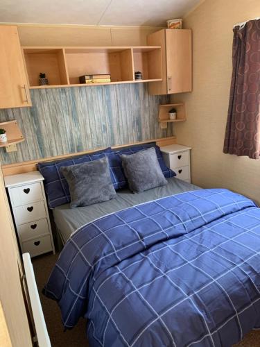 a bedroom with a blue bed with blue sheets at L38 Caravan Mablethorpe With ramp and gated decking in Mablethorpe