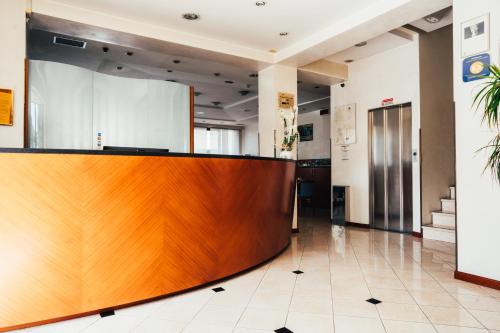 an office lobby with a wooden reception desk at Arcangelo Roof Hotel in Rimini