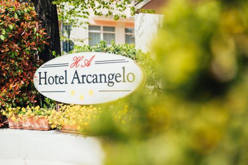 a sign for a hotel americoria in front of flowers at Arcangelo Roof Hotel in Rimini