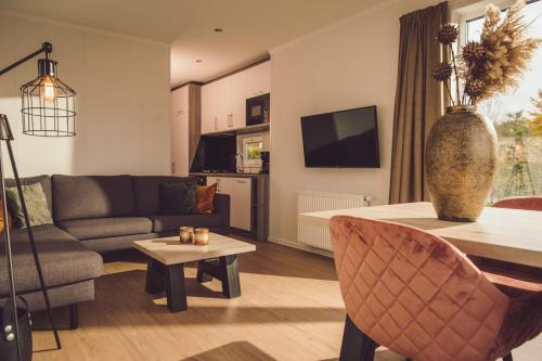a living room with a couch and a table at Tiny Cabin with Hottub I 4 p in Rijssen