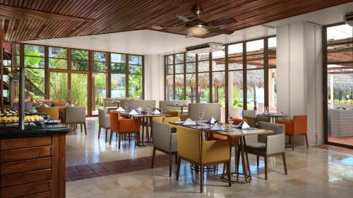 プエルト・バジャルタにあるメリア プエルト バジャルタ オールインクルーシブのテーブルと椅子と窓のあるレストラン