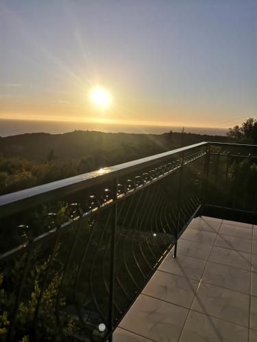 a view of the sunset from the balcony of a building at Santa Maria Rooms in Agios Nikitas