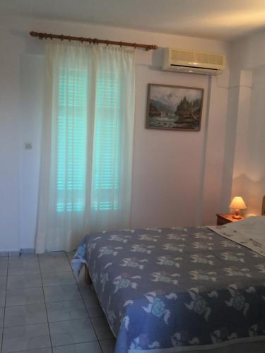 a bedroom with a bed and a window at Santa Maria Rooms in Agios Nikitas
