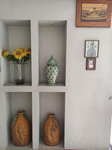 a shelf with vases and pictures on a wall at Hotel México in Morelia