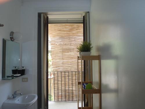 baño con lavabo y aseo y ventana en Gianluca's Room, en Catania