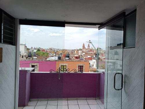a room with a view of a city from a balcony at Hotel México in Morelia
