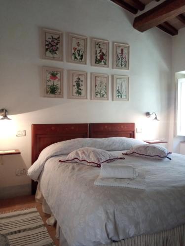 a bedroom with a bed with four pictures on the wall at Casa Demo in Fighine
