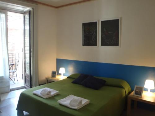 a bedroom with a green bed with two towels on it at Gianluca's Room in Catania