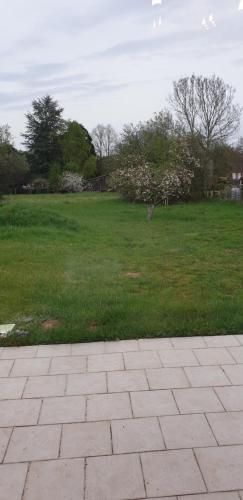 a park with a field of grass and a brick walkway at Maison entre relooking et modernité dans un cadre verdoyant pour amoureux de grands espaces in Nogent-sur-Vernisson