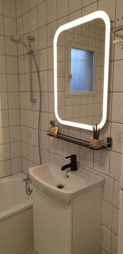 a bathroom with a sink and a mirror and a tub at Maison entre relooking et modernité dans un cadre verdoyant pour amoureux de grands espaces in Nogent-sur-Vernisson