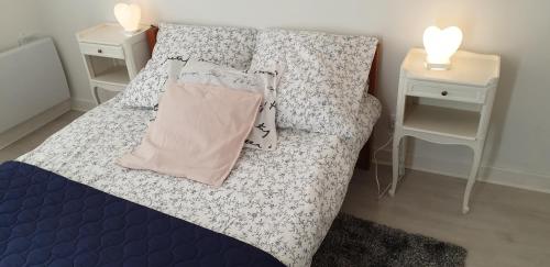a bed in a room with two night stands and two tables at Maison entre relooking et modernité dans un cadre verdoyant pour amoureux de grands espaces in Nogent-sur-Vernisson