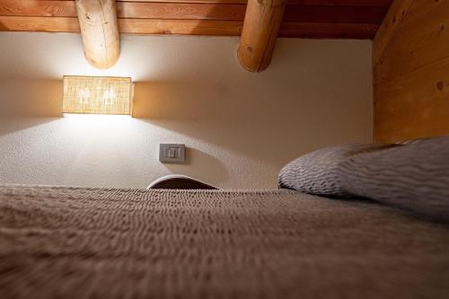 a bedroom with a bed and a light on the wall at Agriturismo Ortesida in Morbegno