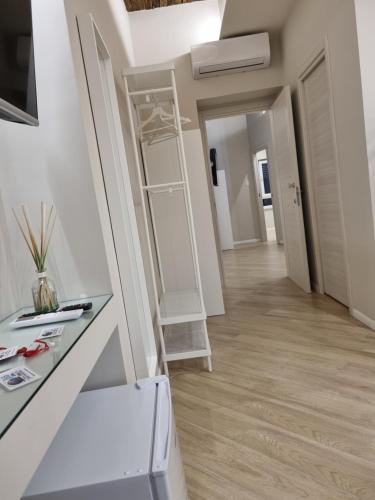 a room with a white refrigerator and a hallway at Cala Di Luna House in Vietri sul Mare