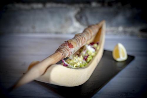 a sandwich in a wrapper with a lemon on a table at Agriturismo Ortesida in Morbegno