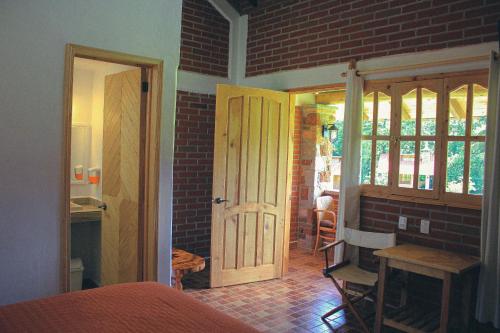 Habitación con puerta y pared de ladrillo en Cabañas Rincón Escondido en Huasca de Ocampo