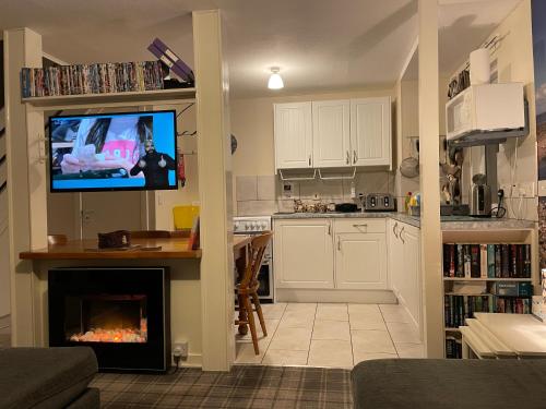 a kitchen with a living room with a fireplace at Lamlash (holiday) Lets in Lamlash