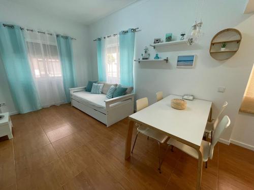 a living room with a table and a couch at Blue Home Monte Gordo in Monte Gordo