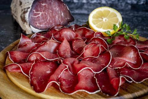a plate of food with meat and a slice of lemon at Agriturismo Ortesida in Morbegno