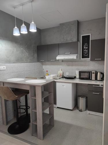 a kitchen with a table and a counter top at Flora Apartment in Surčin