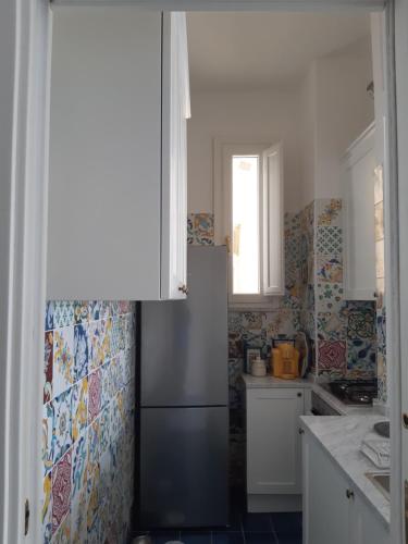 a kitchen with a refrigerator and a window at Salerno Eremita Apartment in Salerno