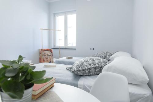 a bedroom with two beds with pillows and a plant at Albergo Libera Gioventù in Torre Annunziata